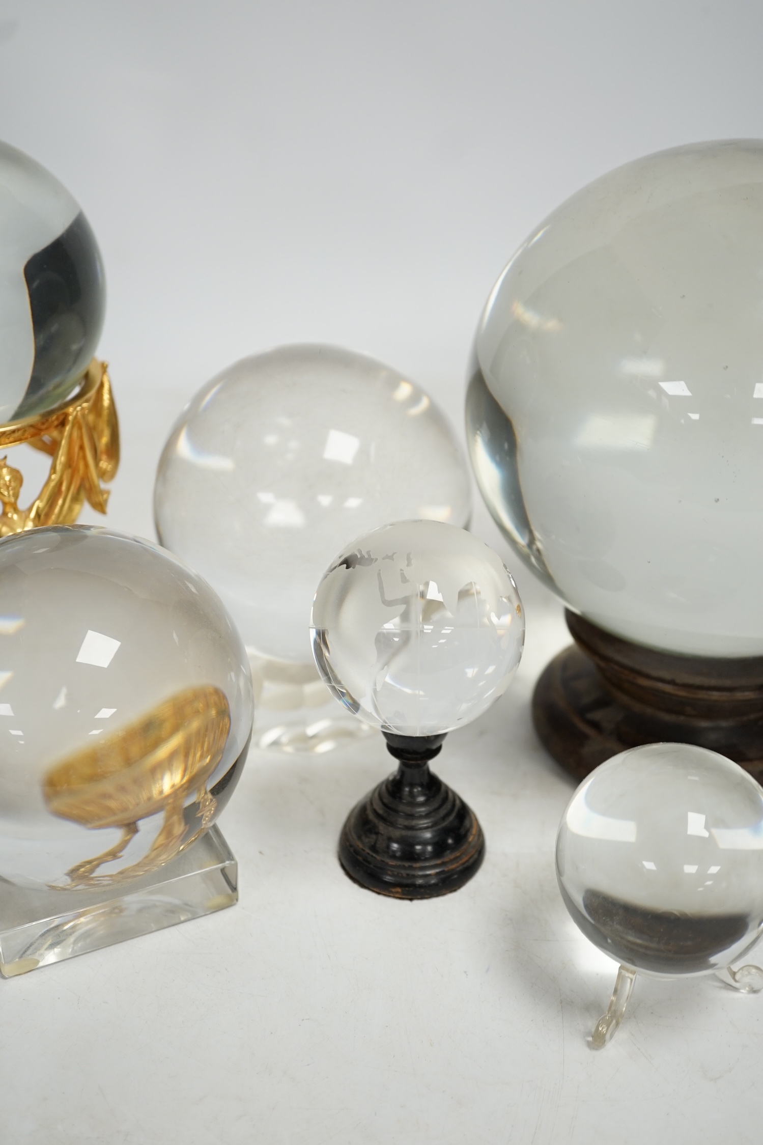 A group of six crystal balls on stands, largest 14cm across. Condition - fair